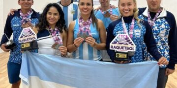 integrantes de la seleccion argentina de racquetball posan con sus medallas y la bandera argentina