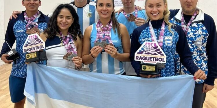 integrantes de la seleccion argentina de racquetball posan con sus medallas y la bandera argentina