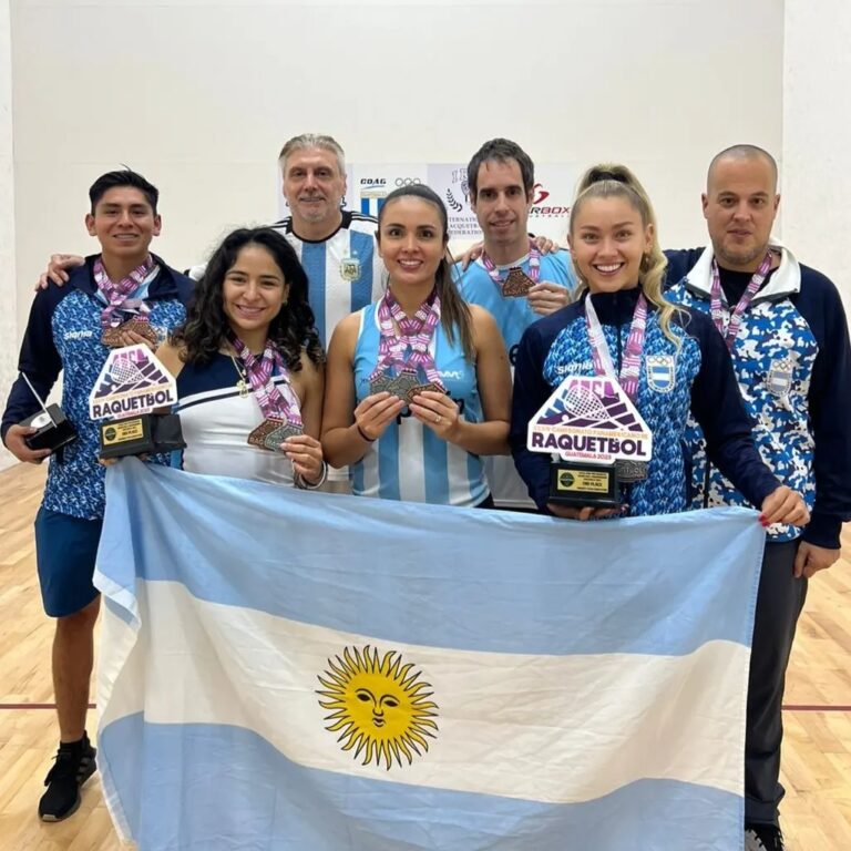 integrantes de la seleccion argentina de racquetball posan con sus medallas y la bandera argentina